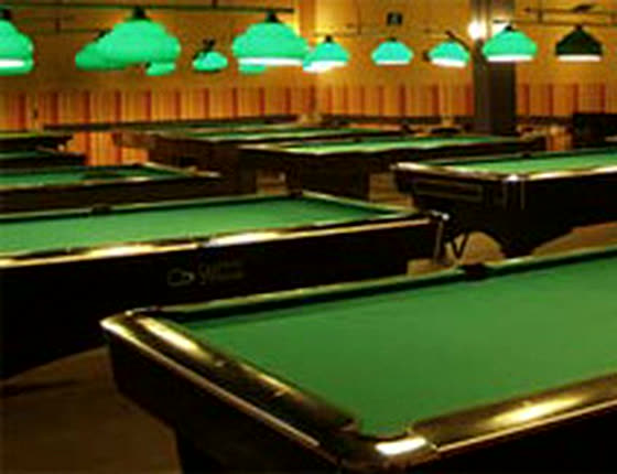 Der Billardsaal im C'est la Vie: Reihen von Pool-Tischen unter grünen Billardlampen
